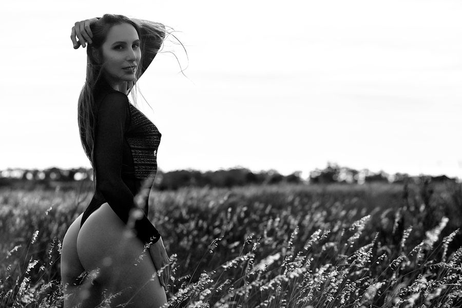 Black and white glamour portrait in a bodysuit in an open field