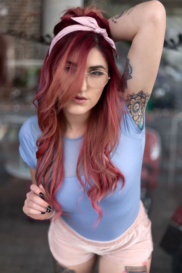 Portrait with pink hair and a headscarf on a city street