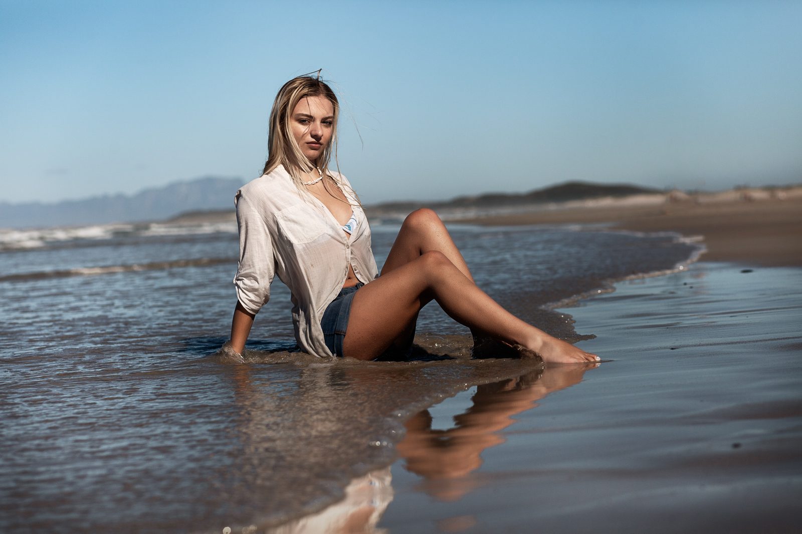 Seated portrait in shallow water at the shoreline