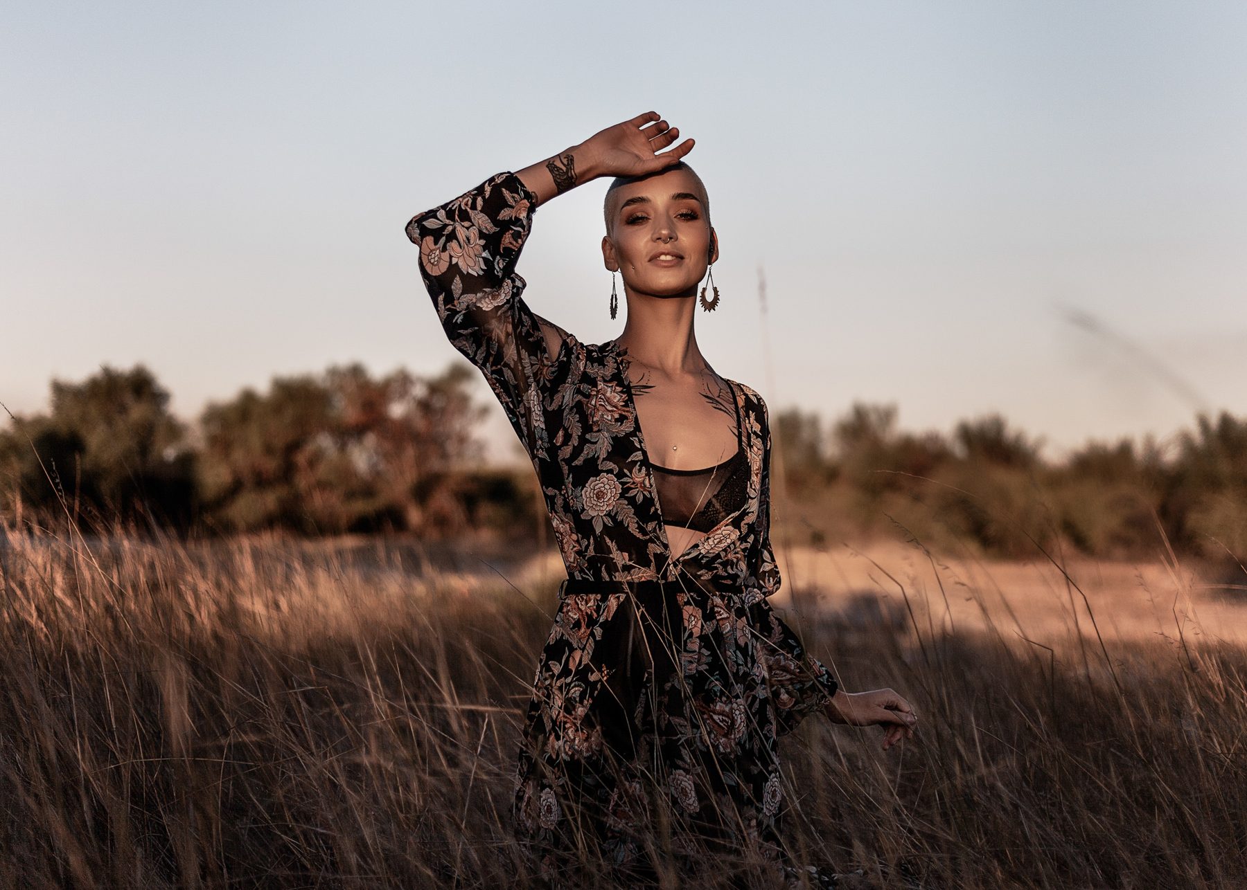 Portrait in a lace dress in an open field at dusk