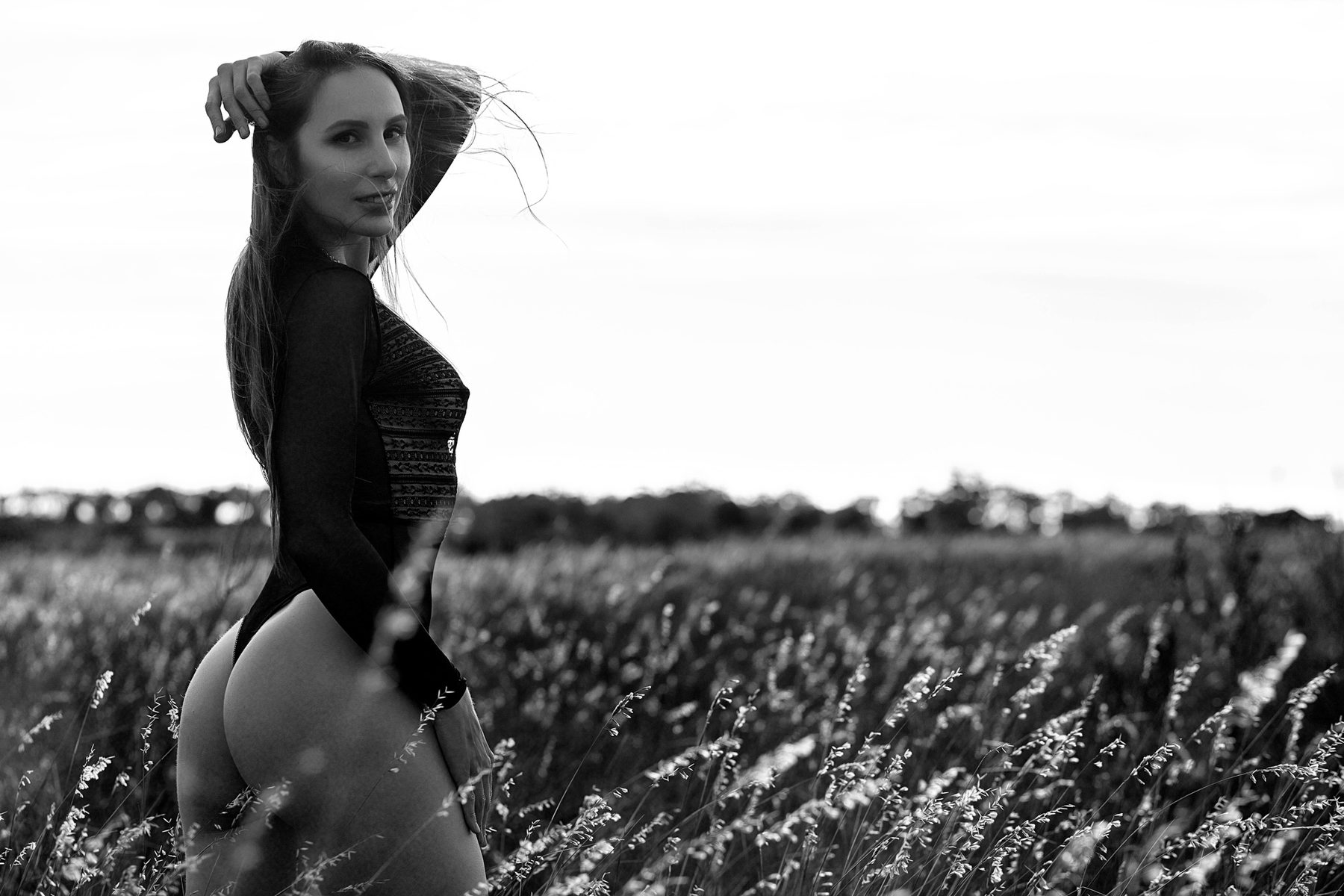 Black and white glamour portrait in a bodysuit in an open field